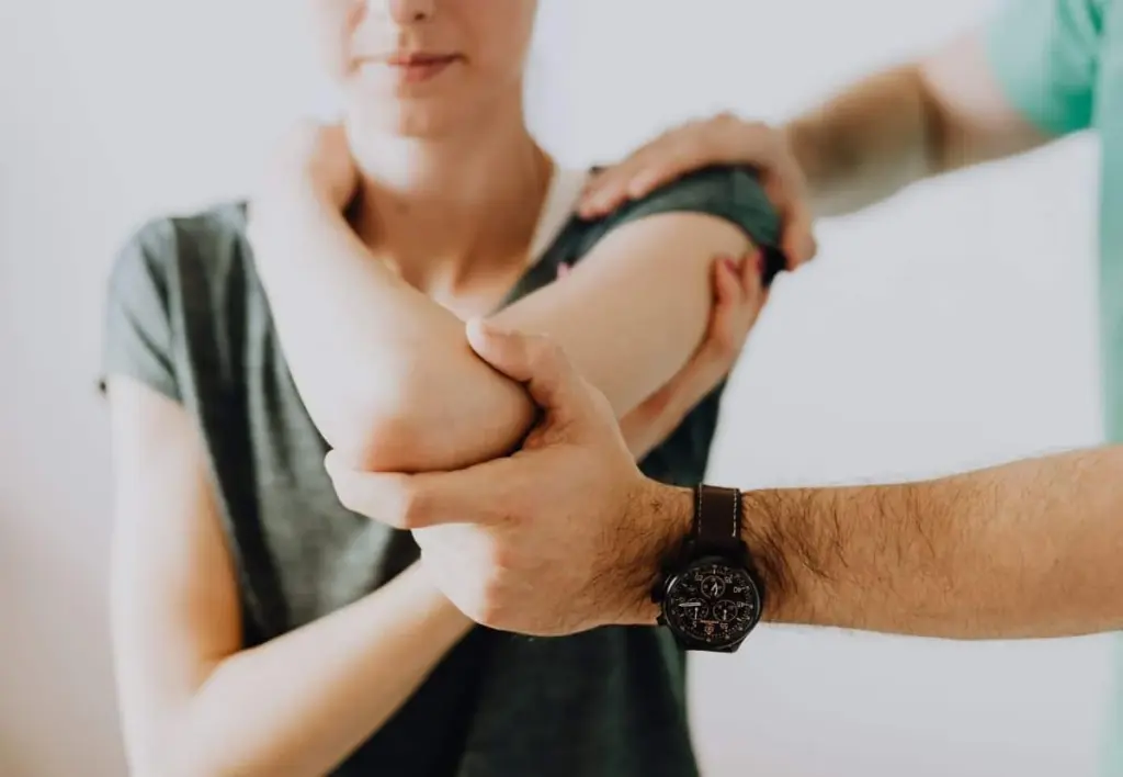 Practitioner mobilizing a woman's elbow and shoulder