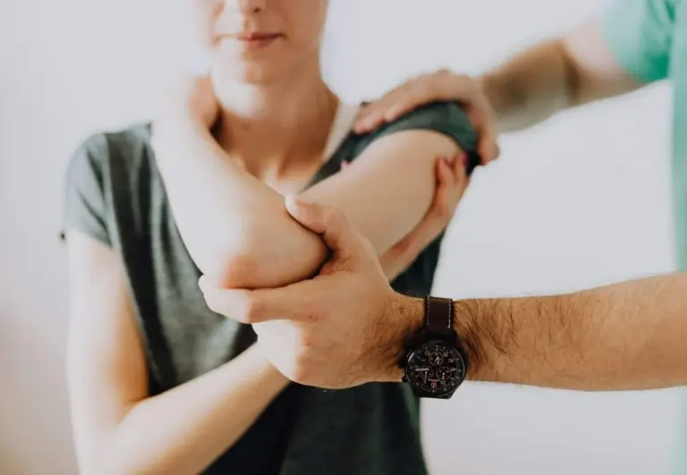 Practitioner mobilizing a woman's elbow and shoulder