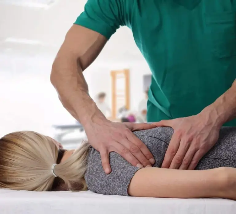 Practitioner pressing on the lower back of a patient lying face down